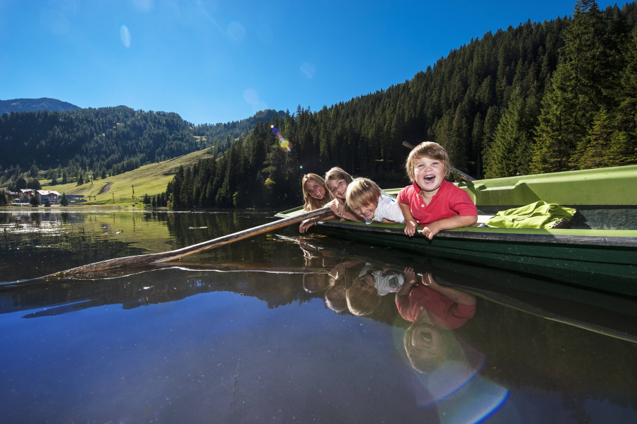 Kinder auf Boot, das auf Bergsee treibt