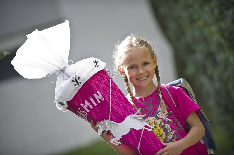 Auf dem Foto ist ein Schulkind mit einer Schultüte zu sehen.