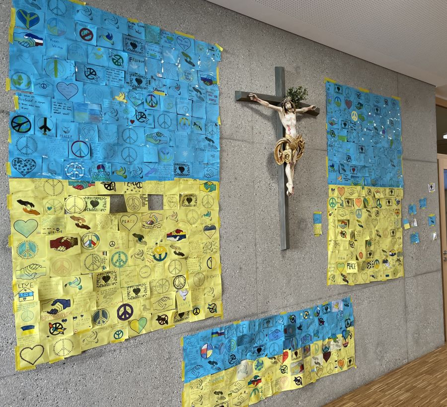 Friedenswand in ukrainischen Farben mit Gebeten von Kindern und Jugendlichen an den Irmengard-Schulen