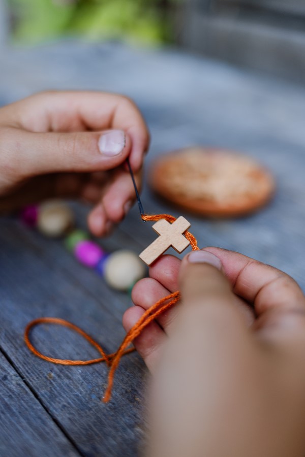 Kind hält Kreuzkette in Händen