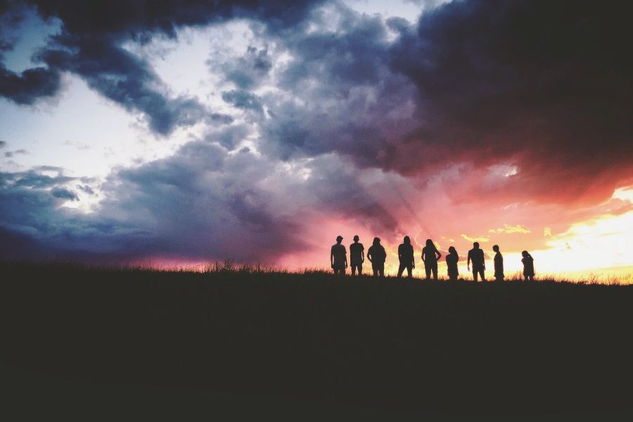 Eine Gruppe Jugendlicher auf einem Berg bei Sonnenuntergang