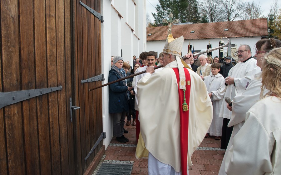 Weihbischof Dr. Bernhard Haßlberger klopft mit dem Bischofsstab an der Kirchenpforte an; Einweihung 20.11.22