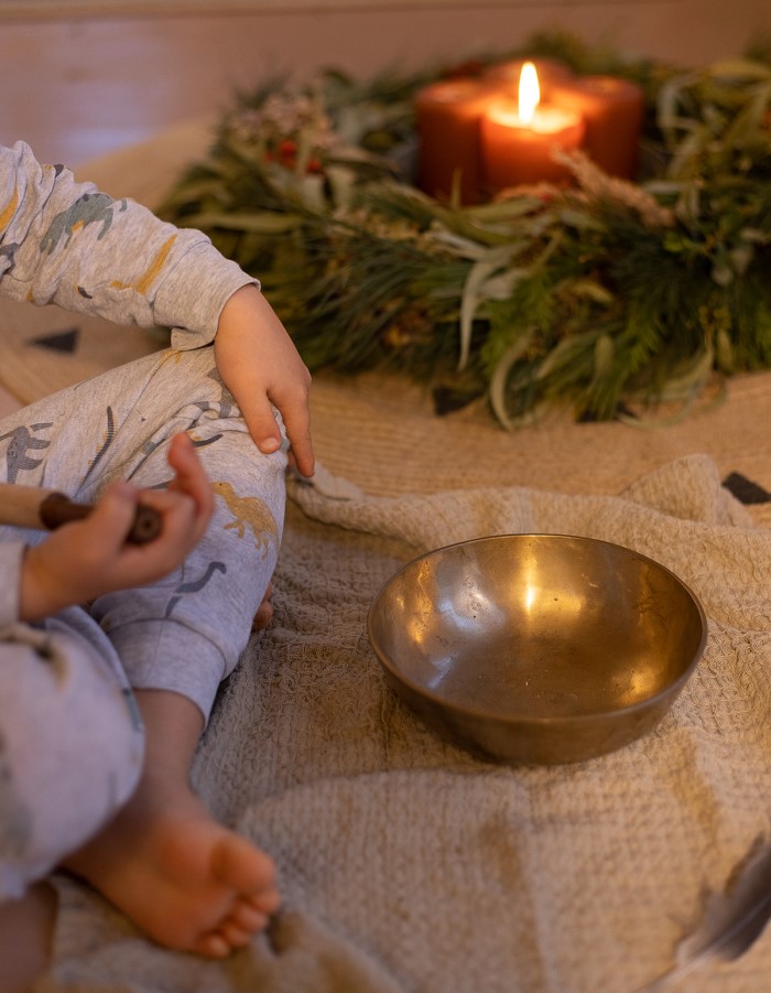 Kind mit Klangschale und Adventskranz für Schatzzeit-Andacht