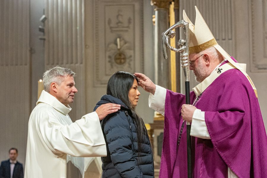 Kardinal Reinhard Marx segnet eine Firmanwärterin bei der Erwachsenenfirmung am 3. Dezember 2022 in der Münchner Frauenkirche