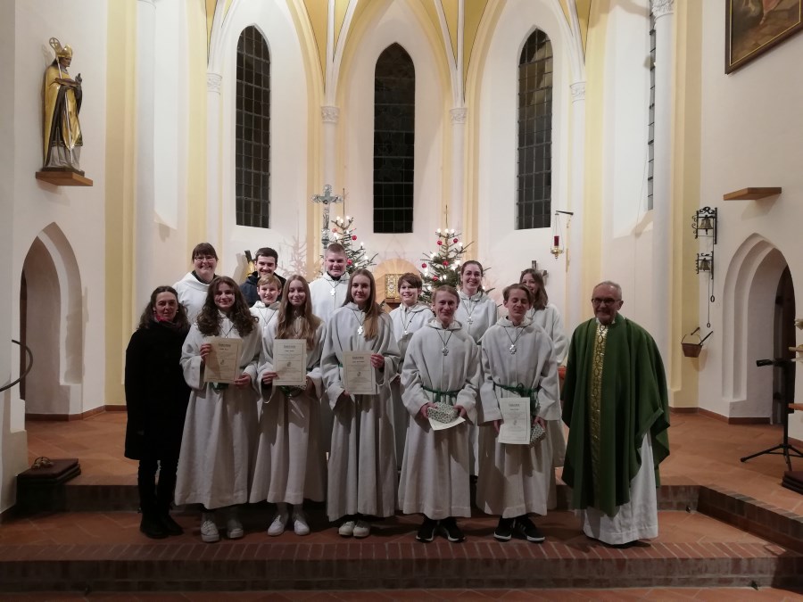 Gruppenbild der Verabschiedung von fünf Ministrant:innen mit Urkunden, Seelsorger:innen und Ministrantenbeauftragte