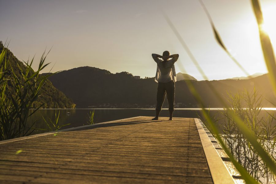 Frau auf Steg in Berglandschaft