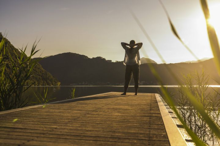 Frau auf Steg in Berglandschaft