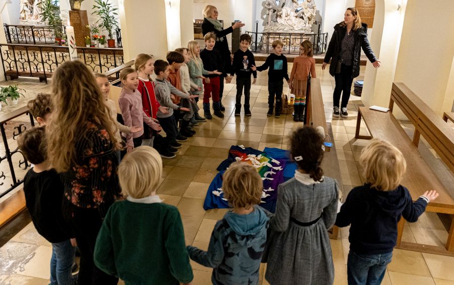 Grundschülerinnen und Grundschüler beten im Bürgersaal der Unterkirche um Frieden