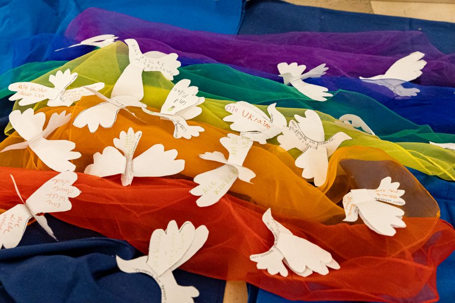 Papier-Friedenstauben auf einer Friedensfahne im Bürgersaal der Unterkirche