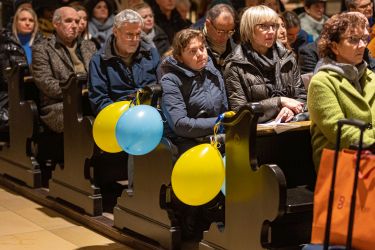 Gottesdienstbesucher mit Luftballons in den ukrainischen Farben blau und gelb während des Ökumenischen Friedensgebets in St. Michael am 24. Februar 2023