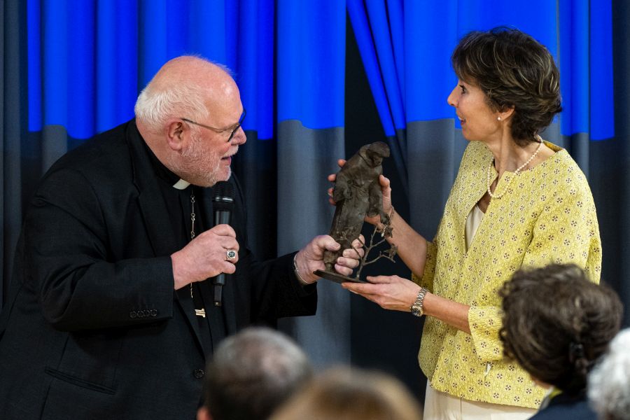 Kardinal Reinhard Marx schenkt Schulleiterin Dunja Schoerrig eine Franziskus-Statue während der Feier in der Franziskus-Grundschule in München-Haidhausen