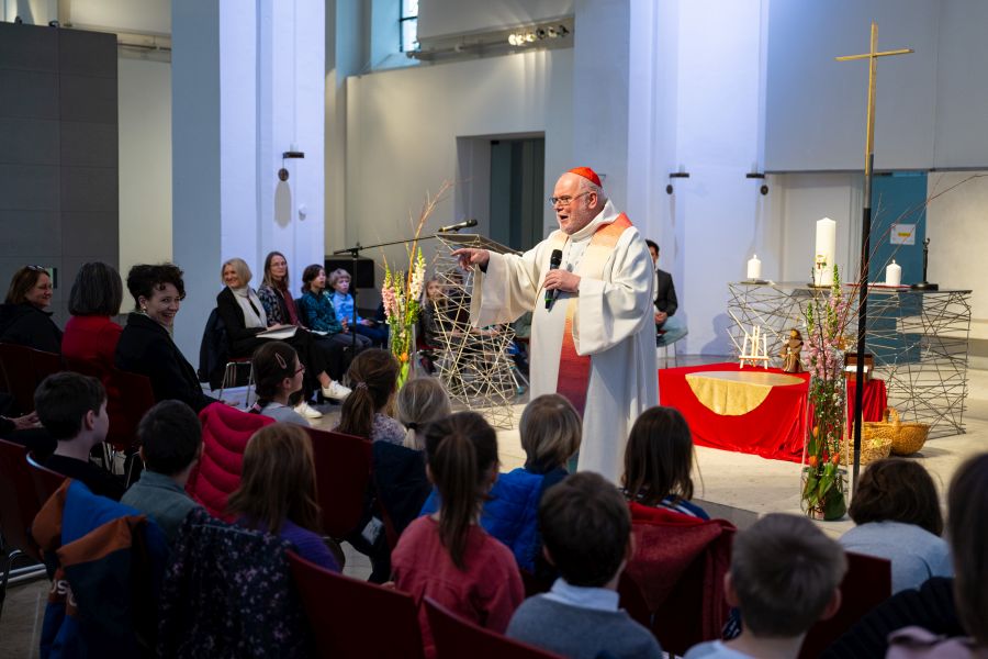 Kardinal Reinhard Marx spricht im Wortgottesdienst in der Campuskirche zu den Schülerinnen der Franziskus-Grundschule