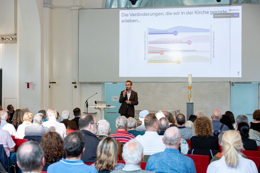 Präsentation der Online-Umfrage durch Moderator Jochen Frericks bei der Informationsveranstaltung zum Gesamtstrategieprozess in München