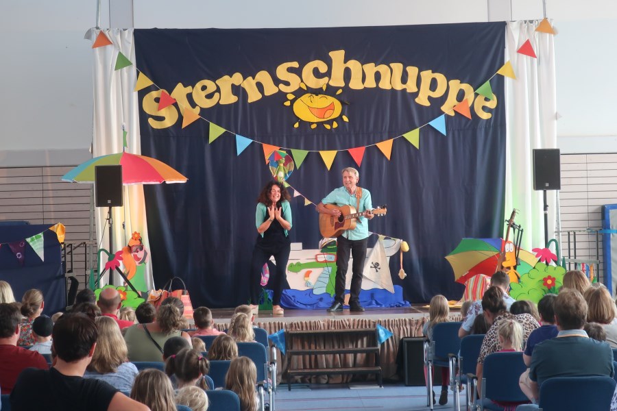 Margit und Werner singen auf der Bühne in der Schulturnhalle die Sommerlieder!