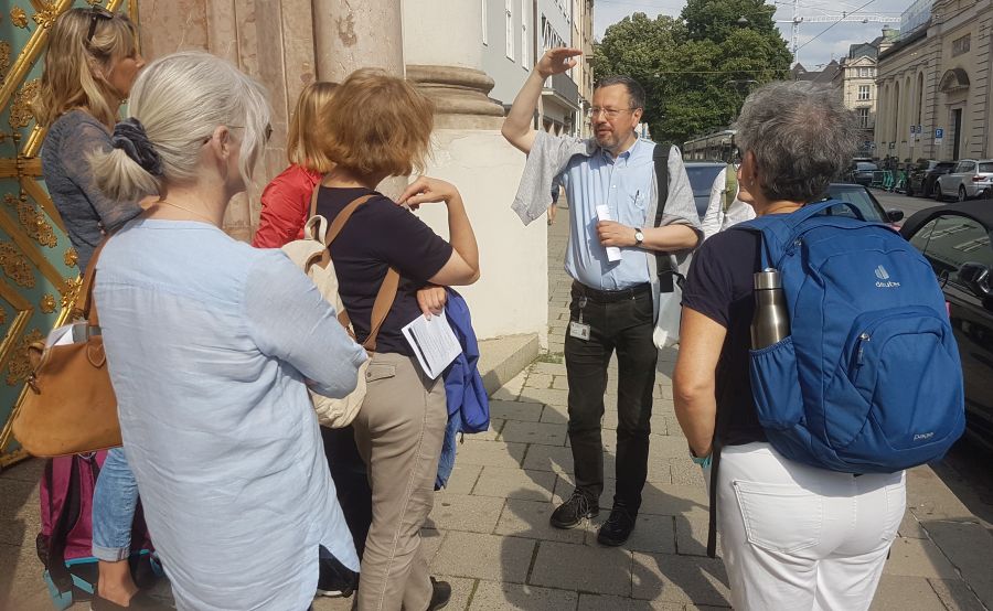 Dr. Roland Götz mit sechs Teilnehmerinnen des Kirchenhistorischen Rundgangs durch die Münchner Innenstadt vor der Dreifaltigkeitskirche