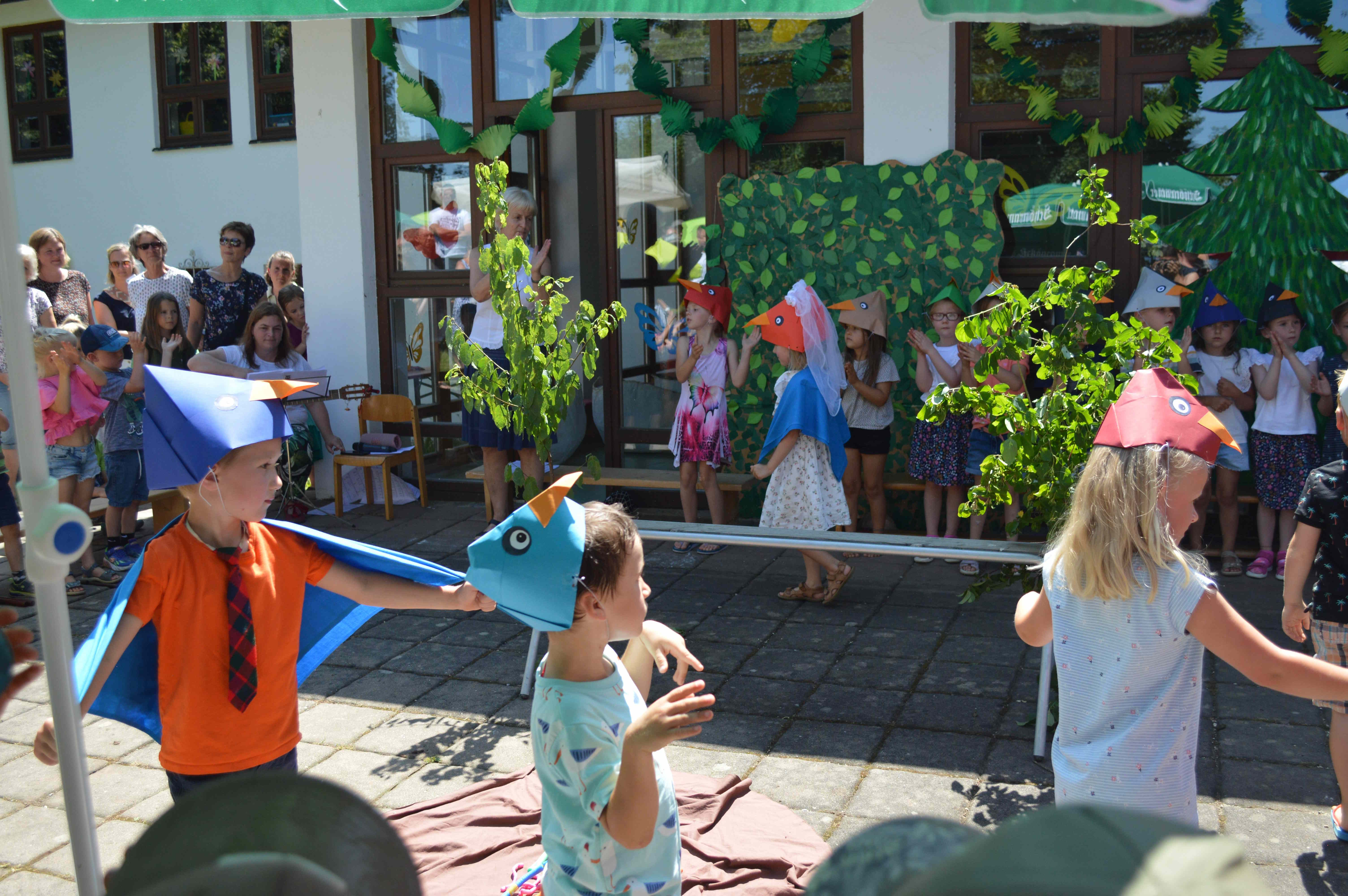 Viele bunte Vögel beim Singspiel Die Mädchen und Buben spielen ihre Rollen mit Begeisterung