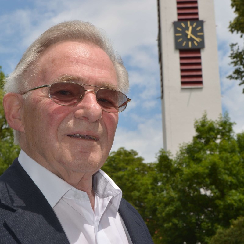 Pfarrer Hans Sinseder, im Hintergrund der Glockenturm von St. Pius X.