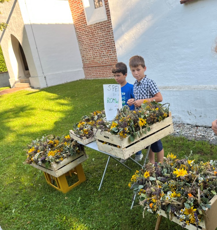 Ministranten der Pfarrei Baierbach bieten gegen eine Spende Kräuterbuschen am Fest Mariä Himmelfahrt an