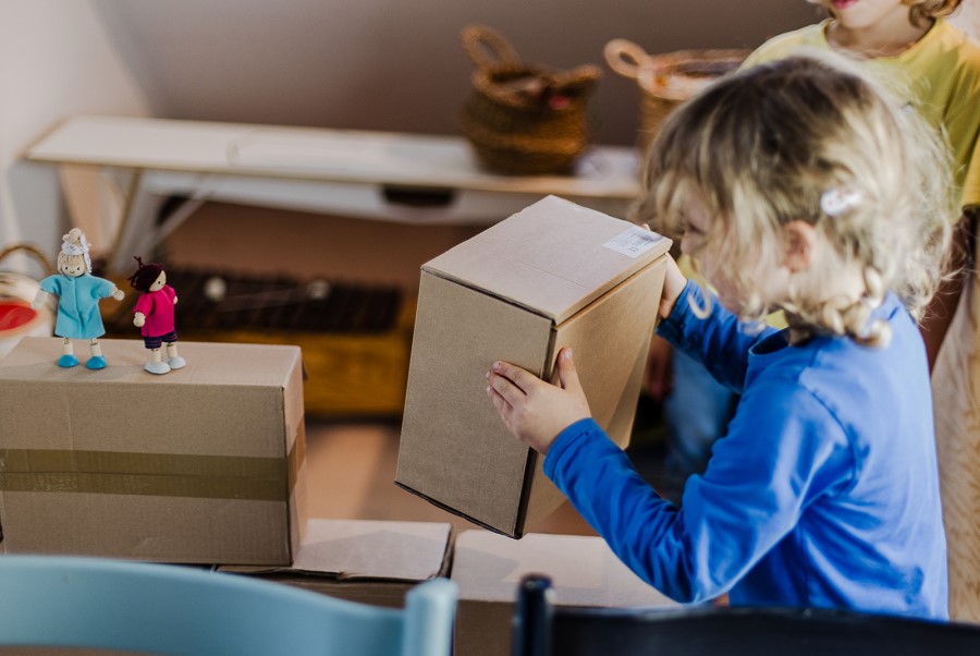Kleines Mädchen baut Burg aus Kartons für die Schatzzeit