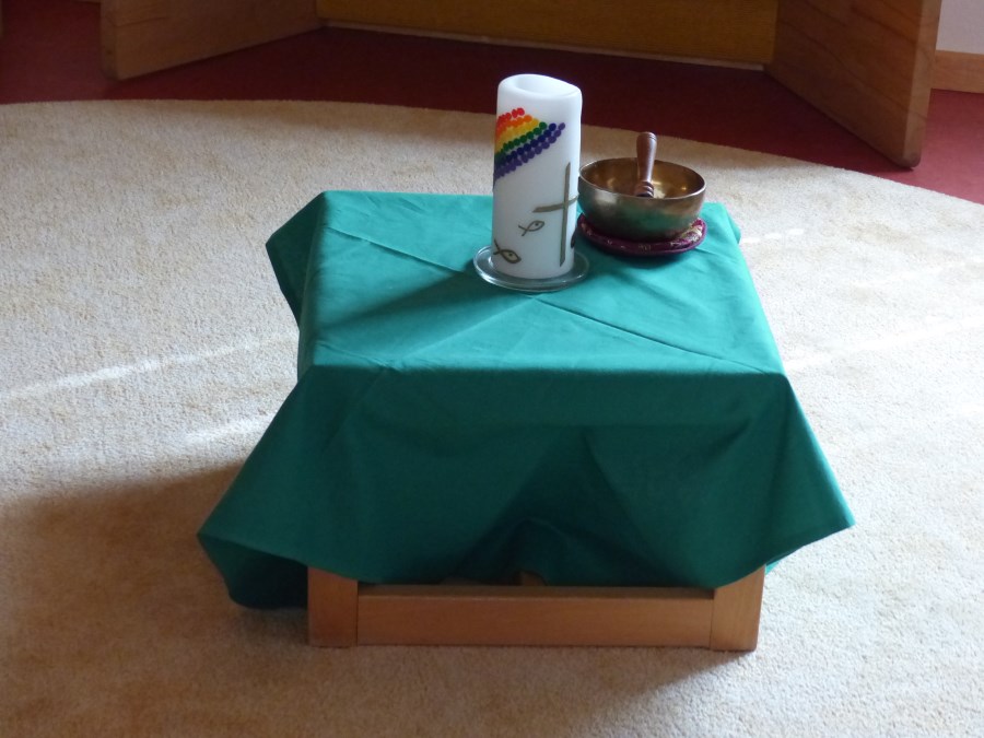 Mittegestaltung einer Sitzrunde mit Kerze und Klangschale auf einem Hocker (bedeckt von einem Tuch)