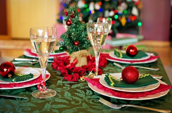 Auf dem Foto ist ein festlich gedeckter Tisch mit Weihnachtsdekoration zu sehen.