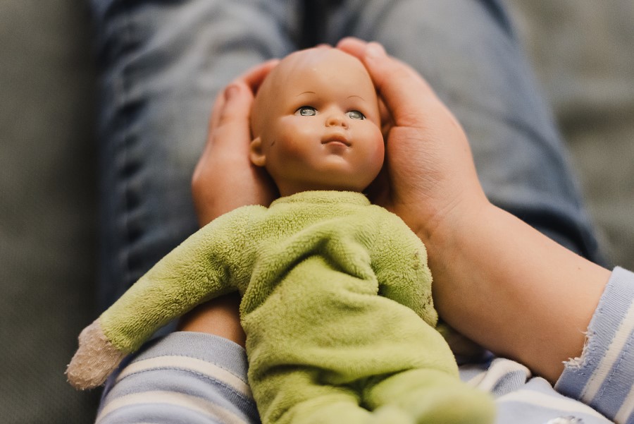 Kind hält Puppe in der Hand