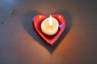 Brennende Kerze auf tönernem Herz