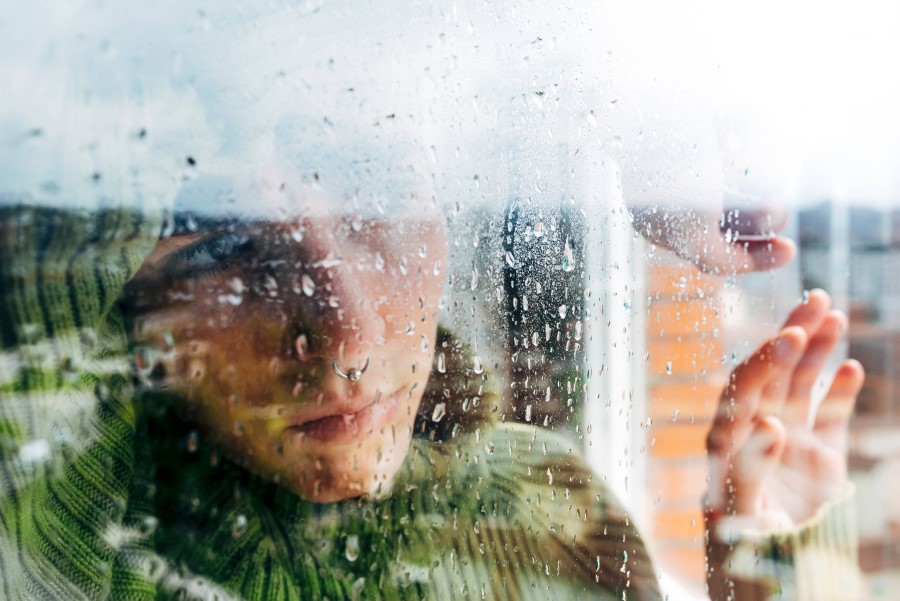 Frau schaut aus dem Fenster