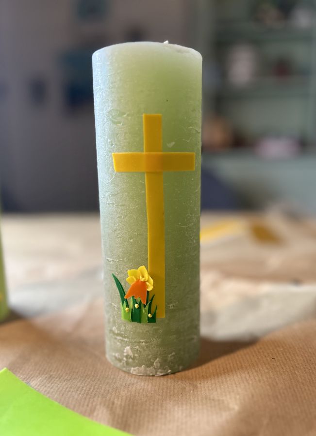 Die Osterkerze 2024 mit den Applikationen Kreuz und Blume