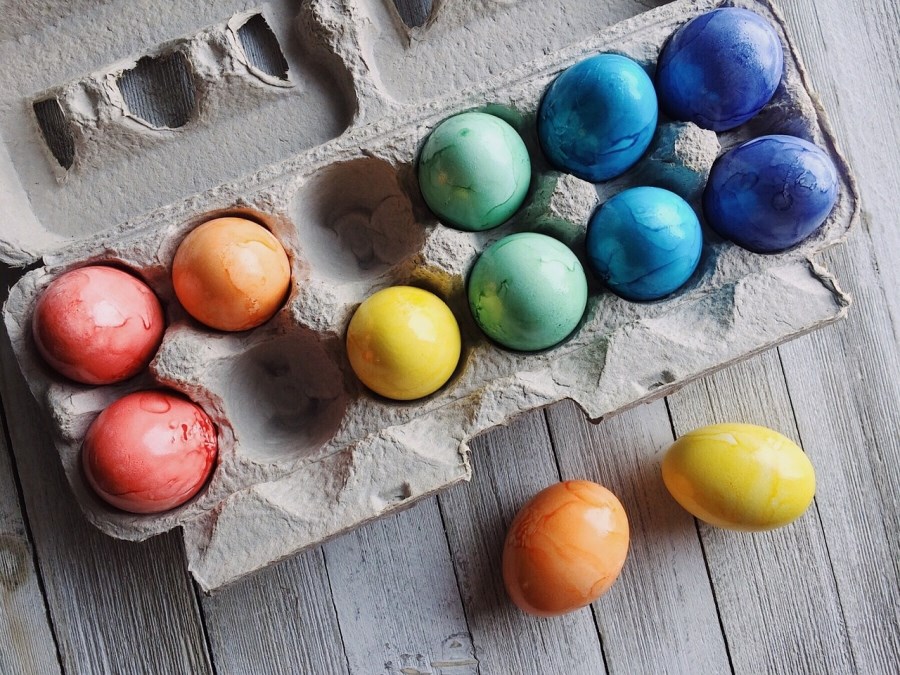 Auf dem Foto sind bunte Eier in einem Eierkarton zu sehen.