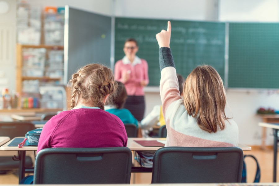 Schülerin meldet sich im Schulunterricht