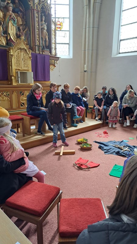 Bild aus dem Zwergerlgottesdienst in Vilsheim im Altarraum der Pfarrkirche und einem Bodenbild zu den Ereignissen von Palmsonntag bis Ostern