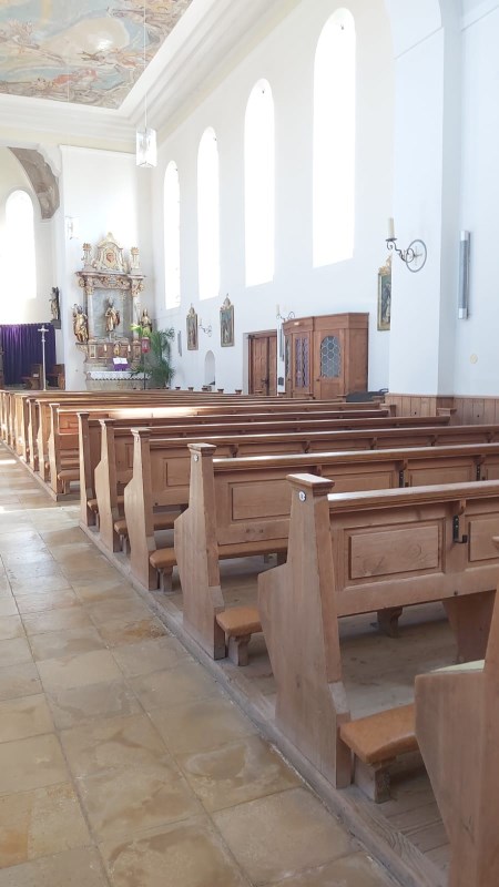 Kirchenraum mit Bänken und Beichtstühlen