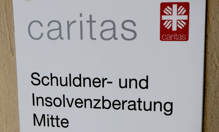 Schild mit der Aufschrift "Caritas: Schuldner- und Insolvenzberatung Mitte"