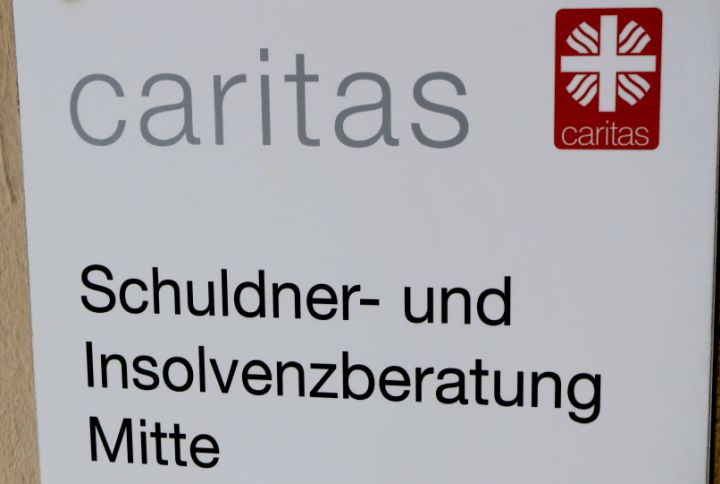 Schild mit der Aufschrift "Caritas: Schuldner- und Insolvenzberatung Mitte"
