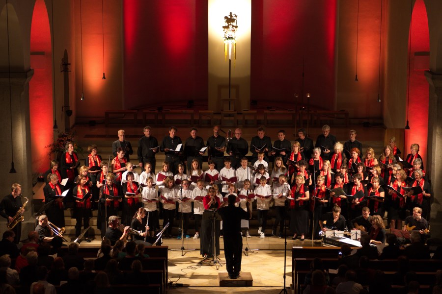 Blick auf den Altarraum mit einem großen Chor mit Erwachsenen und Kindern.