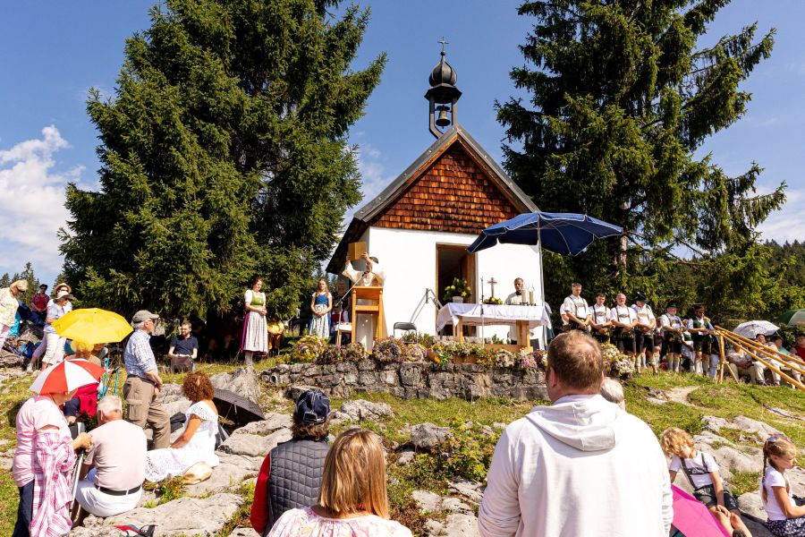 Gottesdienst vor einer Kapelle in den Bergen