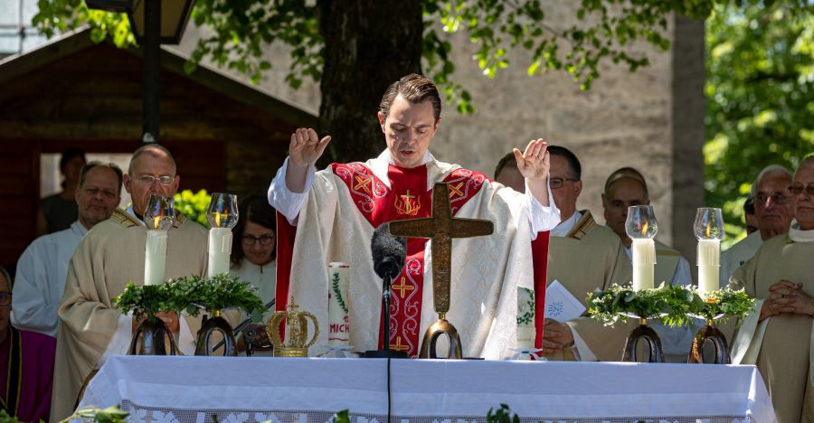 Pfarrer am Altar bei Gottesdienst im Freien