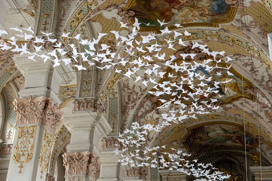 Fliegende Papiertauben in der Heilig-Kreuz-Kirche in München.