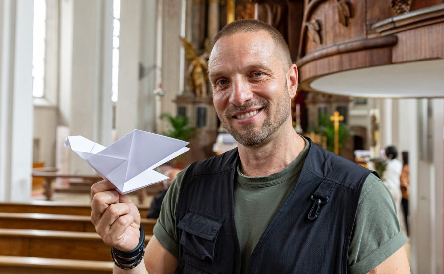 Künstler Michael Pendry mit einer Papiertaube