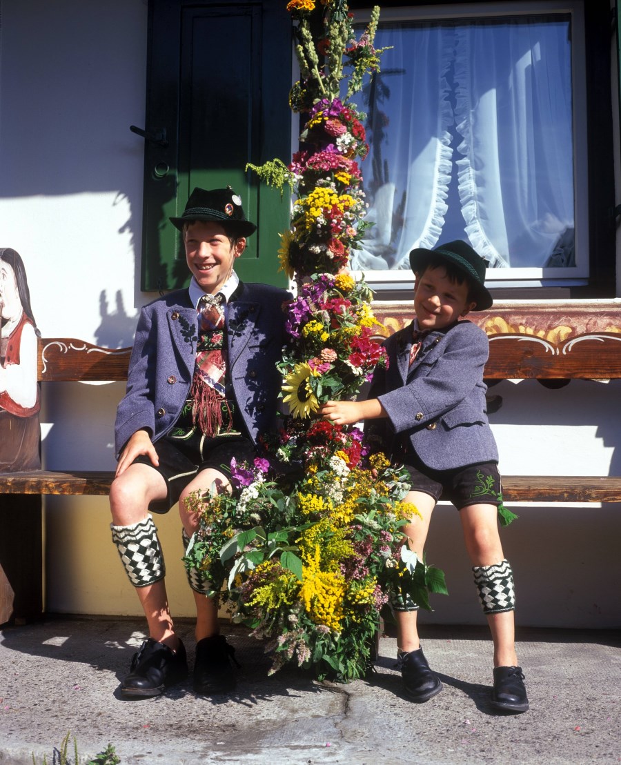 Auf dem Foto sind Buben in bayrischer Tracht bei der Kräuterweihe zu Mariä Himmelfahrt in Garmisch-Partenkirchen zu sehen.