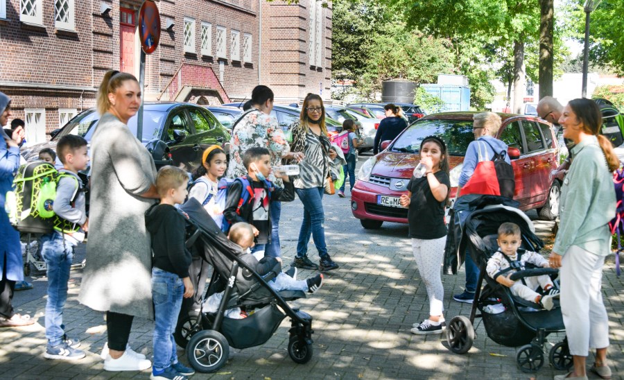 Auf dem Foto sind Mütter und Kinder zu sehen. Die Mütter unterhalten sich und holen ihre Kinder ab.<br/>Elterntaxi