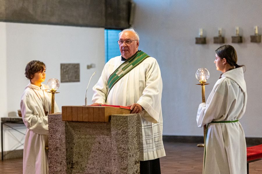 Diakon Walter Schwind während einer Messe am Altar mit zwei Messdienerinnen