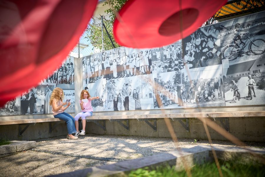 Zwei Mädchen sitzen im Hof der Gedenkstätte Badehaus