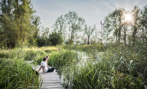 Ein Paar sitzt auf einem Steg an einem See