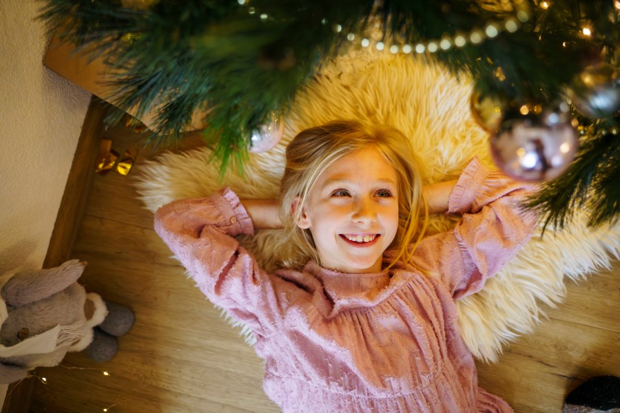 Mädchen unter einem Christbaum