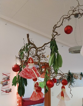 Zweig mit selbst gebastelter Deko