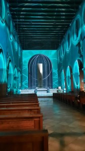 Kircheninnenraum ausgeleuchtet mit blauen Farbornamenten