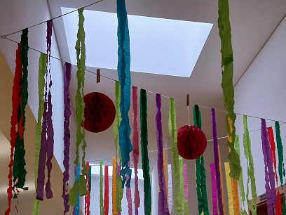 bunte Papierstreifen und Bälle als Deko an der Decke