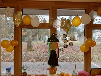 mit selbstgebastelten Hexen und Luftballonen dekoriertes Fenster
